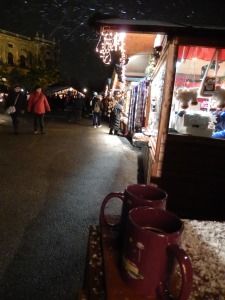 our two mugs of glühwein, market stalls behind